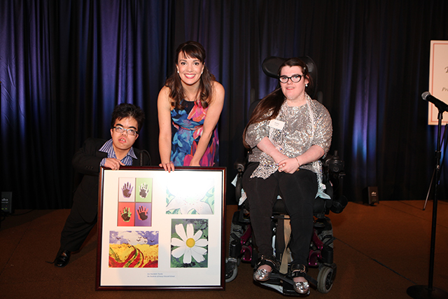 Broadway's Kara Lindsay while holding a piece of art work with two students from the Henry Viscardi School at the Reach for a Star Luncheon.